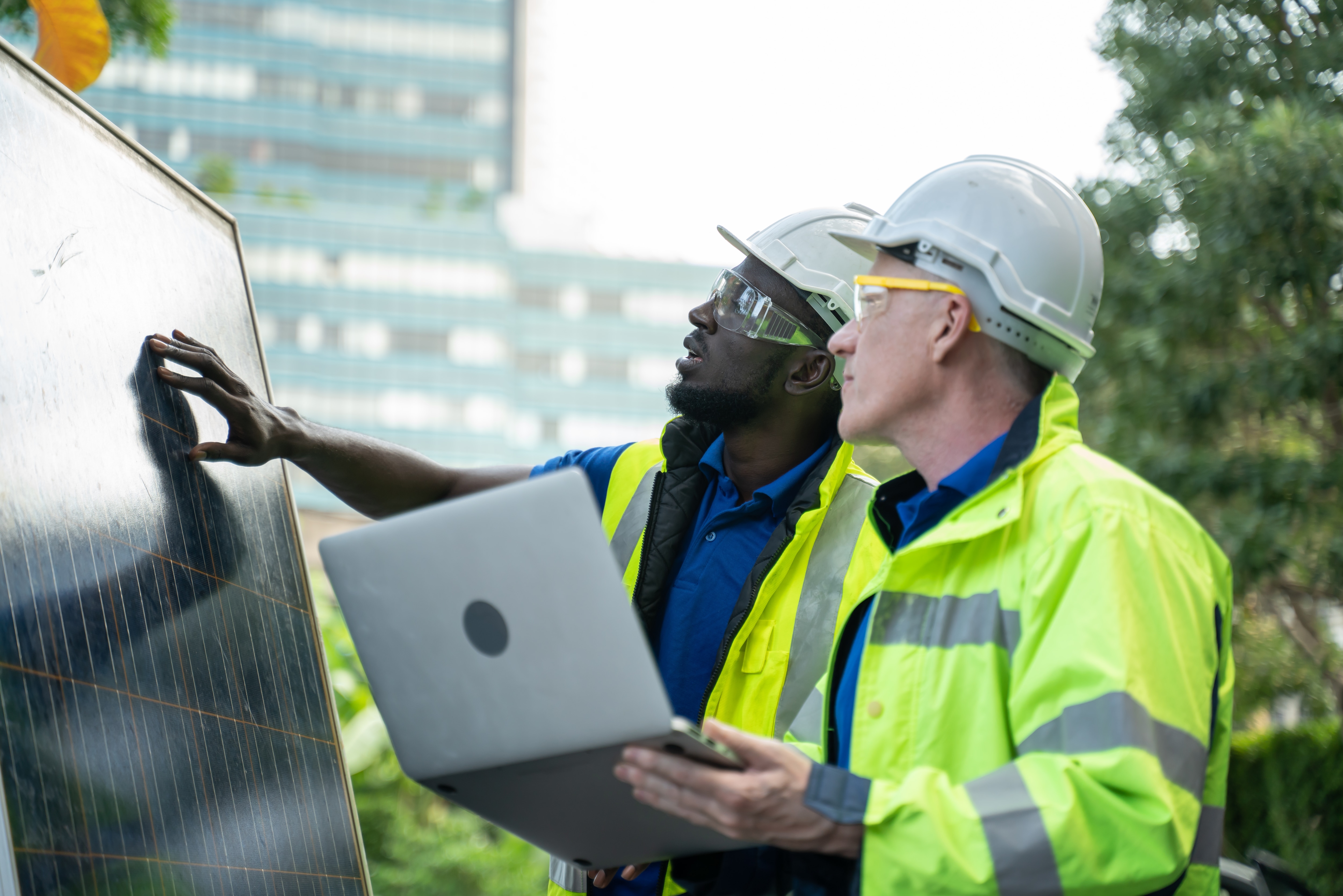 Two people look at outdoor solar panels.