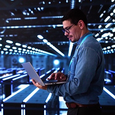 Man works on laptop in an AI data center.