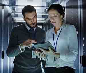 Engenheiros no data center analisando um relatório