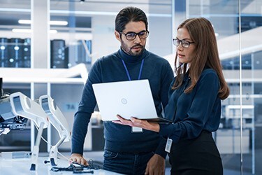 A equipe de engenharia assiste a vídeos de produtos em um laptop.