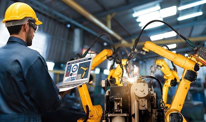 Female engineer operates a cobot in an automated factory.