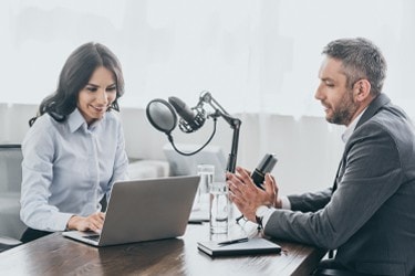 Male engineer speaks with a female journalist about innovation in transportation technologies.