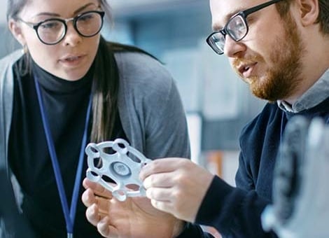 Materials scientists in a materials science laboratory examine a 3D-printed prototype.