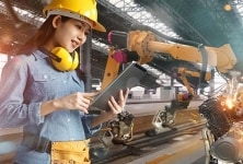 産業生産現場で工場用ロボットをプログラミングする女性エンジニア。