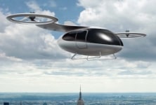 An eVTOL flies across an urban center. 