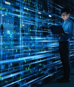 An engineer measures performance in a data center rack.