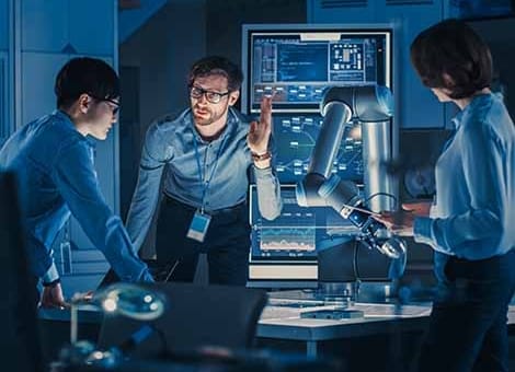 Engineers working on a robotic arm for a smart factory.