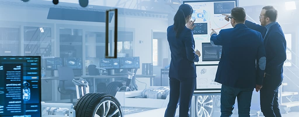 Automotive engineers discuss a vehicle architecture.