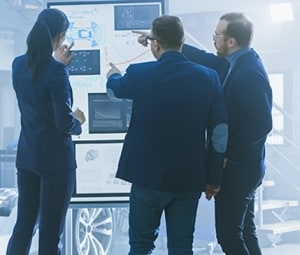 Automotive engineers discuss a vehicle architecture.