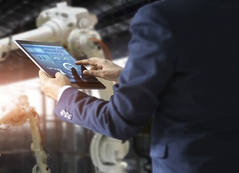 Engineers in a factory operate a cobot.