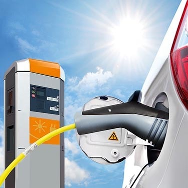 Man and woman charge their electric car at an EV charging station.