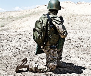 kniender Soldat mit Helm und Ausrüstung