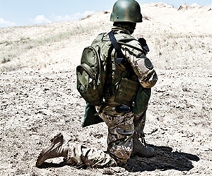 soldat à genoux avec son casque et son équipement